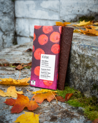 The Superior Dark Cranberry Chocolate by VIVANI in an autumnal setting.
