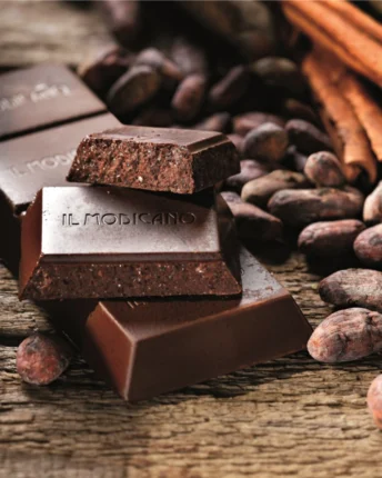 Sizilianische Modica-Schokolade von Il Modicano mit Kakaobohnen im Hintergrund