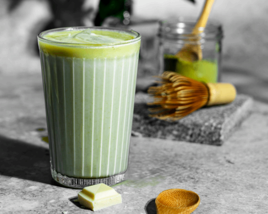 matcha-latte-weisse-schokolade-vivani-small Ein Glas Matcha Latte mit weißer Schokolade und Eiswürfeln von VIVANI Bio-Schokolade.
