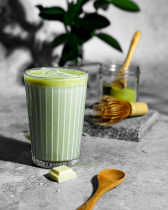 Ein Glas Matcha Latte mit weißer Schokolade und Eiswürfeln von VIVANI Bio-Schokolade.