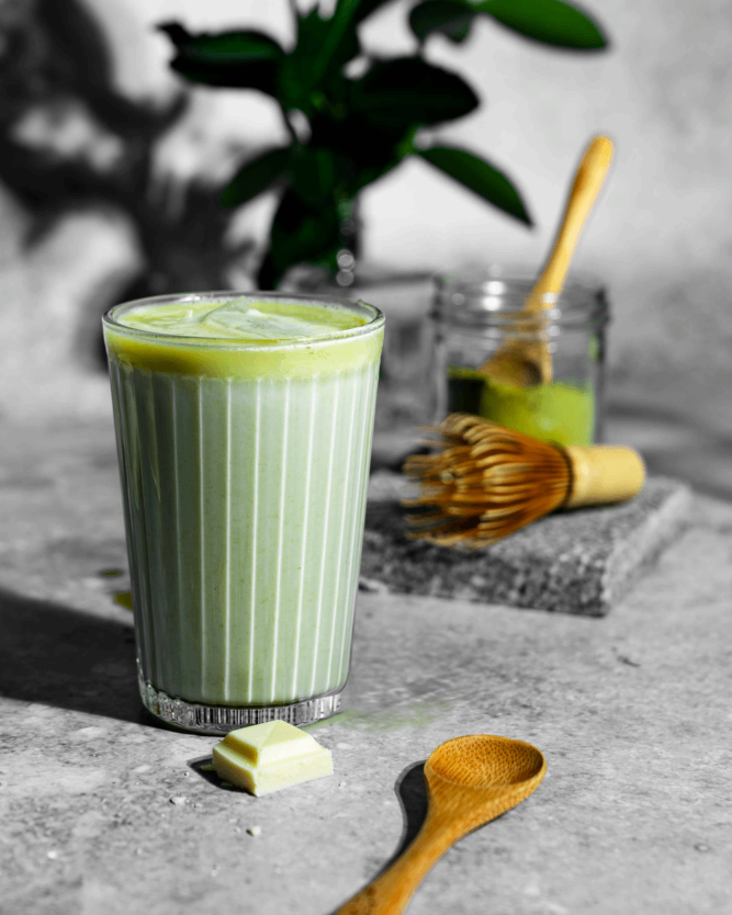 Ein Glas Matcha Latte mit weißer Schokolade und Eiswürfeln von VIVANI Bio-Schokolade.