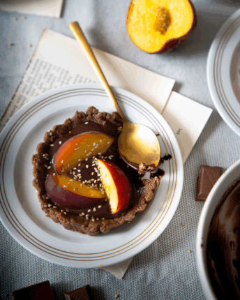 No-bake Tartelettes mit Schokoladenfüllung und mit frischen Pfirsichen belegt.