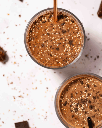 Schoko-Bananen-Smoothie mit Sesamsamen und Schokosplittern bestreut.