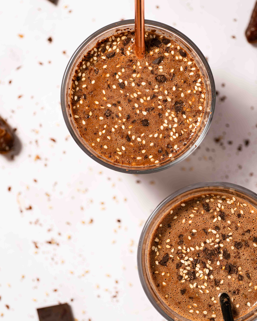 Schoko-Bananen-Smoothie mit Sesamsamen und Schokosplittern bestreut.