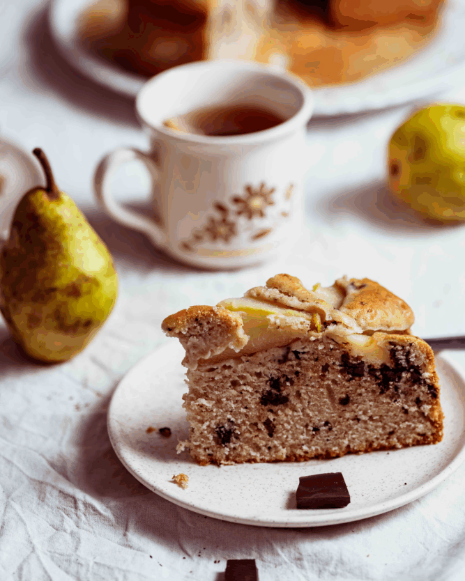 Schoko-Birnen-Kuchen mit einer Tasse Tee und Birnen.