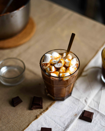 Ein Glas heiße Schokolade mit Marshmallows und Soja-Karamellsauce.