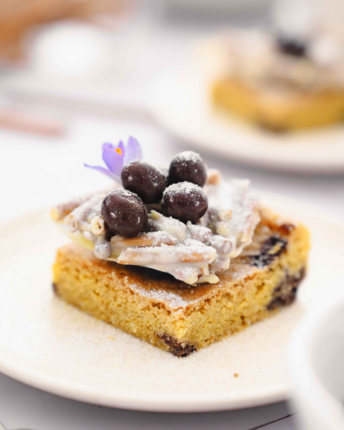 Ein quadratischer Blondie mit weißem Schoko-Salzstangen-Osternest und kleinen Schokoladenostereiern.