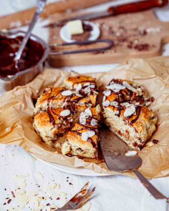 Dreieckige Triple Chocolate Scones mit Schokoladenganache und Mandelblättchen.