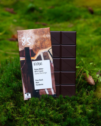 Die Schokoladentafel VIVANI Feine Bitter 85 % Cacao auf einem mosigen Boden.